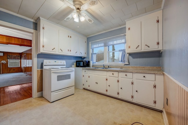 kitchen with electric range, white cabinetry, crown molding, and wooden walls