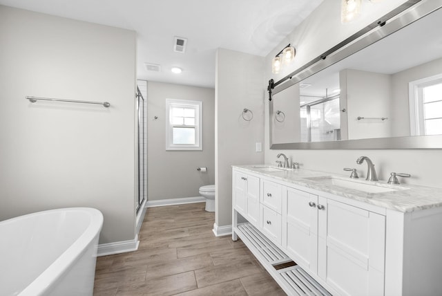 full bathroom with toilet, hardwood / wood-style floors, vanity, and separate shower and tub