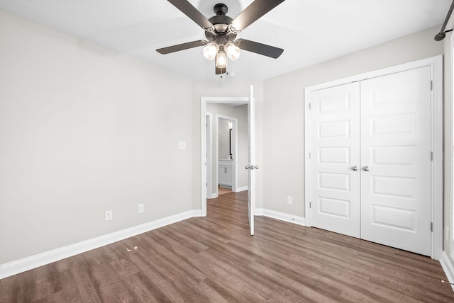 unfurnished bedroom featuring ceiling fan, wood-type flooring, and a closet