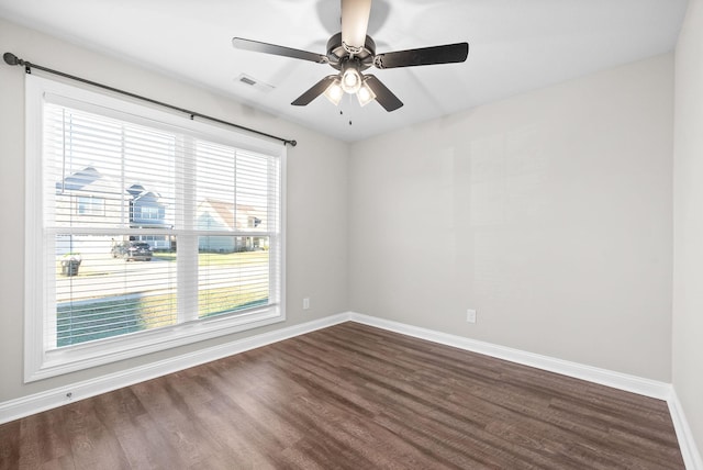 empty room featuring ceiling fan, dark hardwood / wood-style flooring, and a healthy amount of sunlight