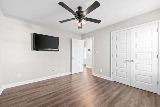 unfurnished bedroom featuring ceiling fan, wood-type flooring, and a closet