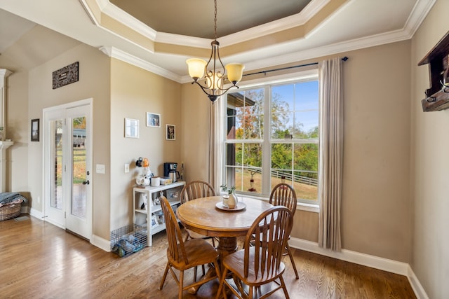 dining space with a wealth of natural light, ornamental molding, and wood-type flooring