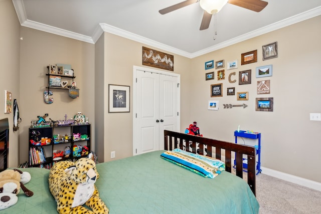 carpeted bedroom featuring crown molding, a closet, and ceiling fan