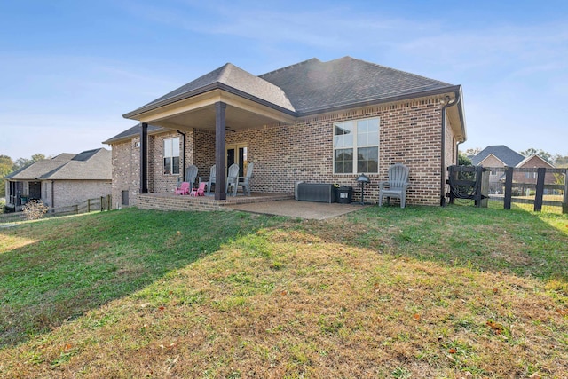 rear view of house with a patio and a lawn