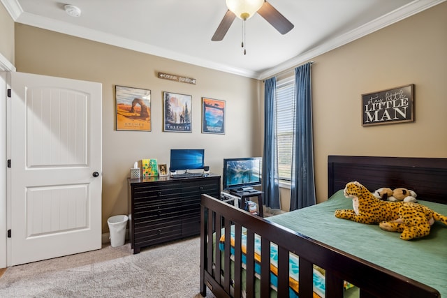 carpeted bedroom with ornamental molding and ceiling fan