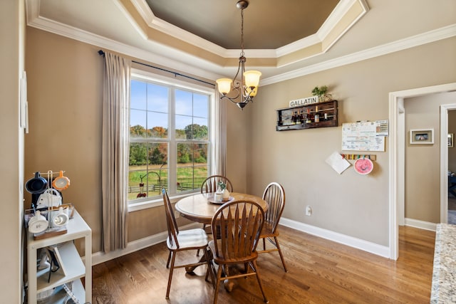 dining area featuring a notable chandelier, hardwood / wood-style flooring, and ornamental molding