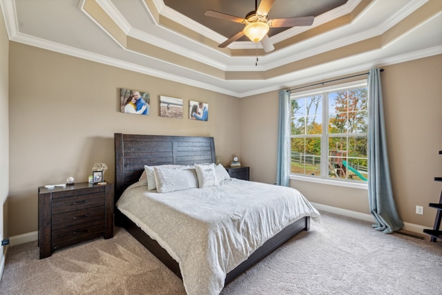 bedroom with crown molding, a raised ceiling, light carpet, and ceiling fan