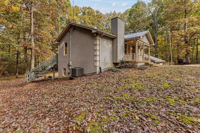 view of property exterior with central AC and a porch