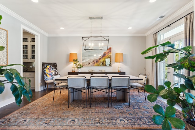 dining space with crown molding, a chandelier, and dark hardwood / wood-style floors