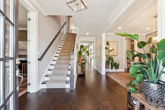 entryway with an inviting chandelier, crown molding, and dark hardwood / wood-style floors