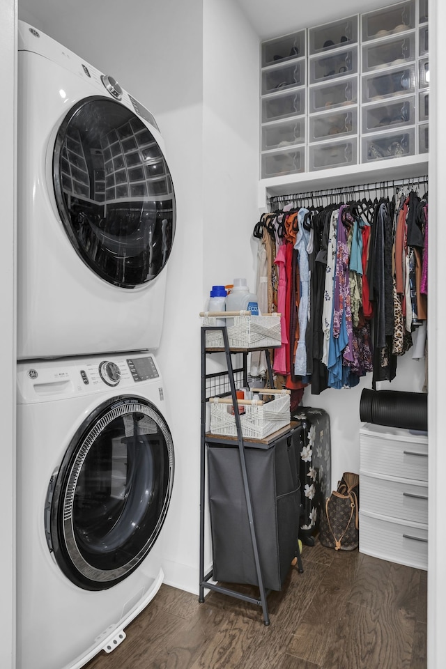 clothes washing area with dark wood-type flooring and stacked washer and dryer