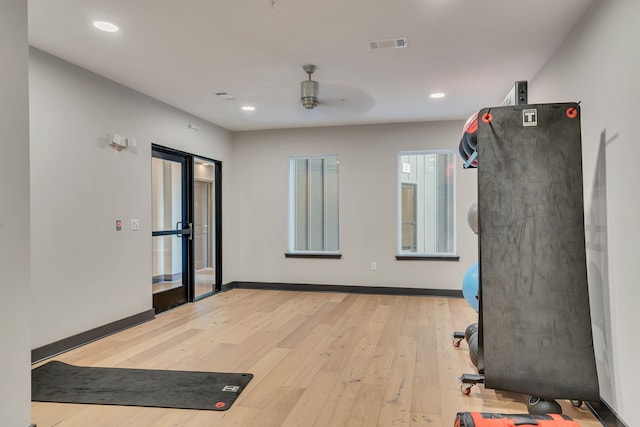 workout room with light wood-type flooring and ceiling fan