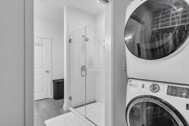 clothes washing area with stacked washing maching and dryer