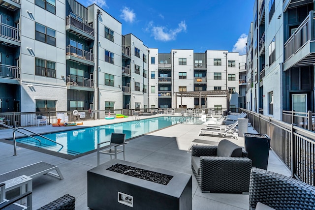 view of swimming pool featuring a patio and an outdoor fire pit