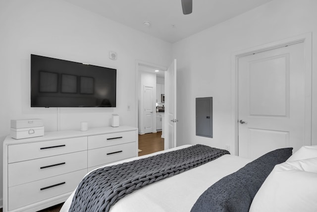 bedroom with dark hardwood / wood-style flooring, electric panel, and ceiling fan