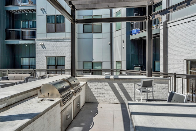 view of patio featuring area for grilling, an outdoor kitchen, and a balcony