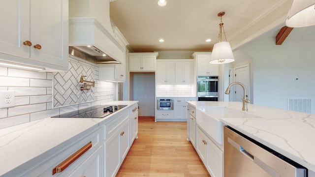 kitchen with backsplash, appliances with stainless steel finishes, decorative light fixtures, and white cabinets