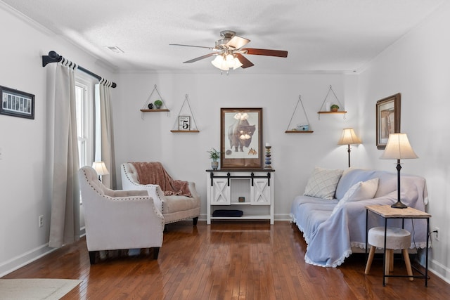 sitting room with dark wood-type flooring, crown molding, a textured ceiling, and ceiling fan