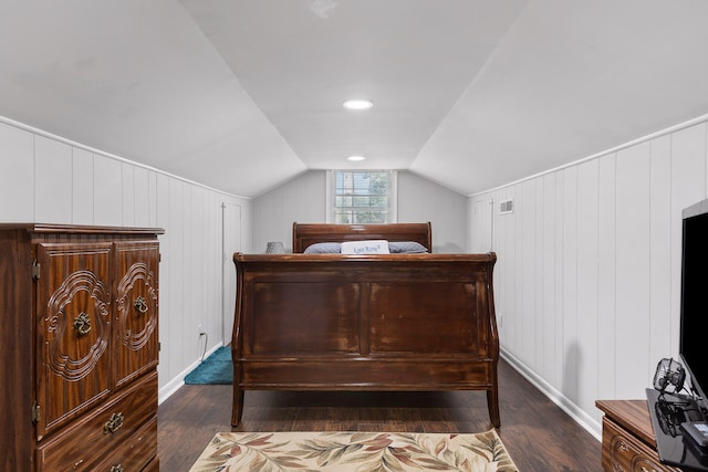 bedroom featuring wood walls, vaulted ceiling, and dark hardwood / wood-style flooring