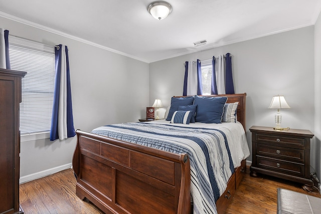 bedroom with crown molding and dark hardwood / wood-style flooring