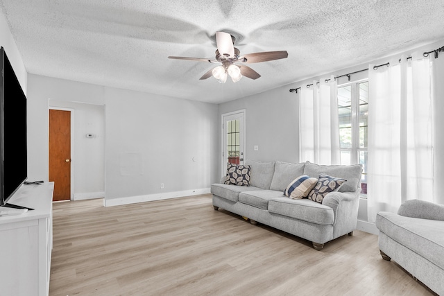 living room with a textured ceiling, light wood-type flooring, and ceiling fan