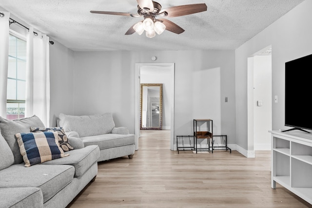 living room with a textured ceiling, light hardwood / wood-style floors, and plenty of natural light