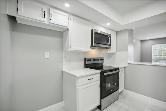 kitchen with white cabinetry, appliances with stainless steel finishes, light tile patterned flooring, and decorative backsplash