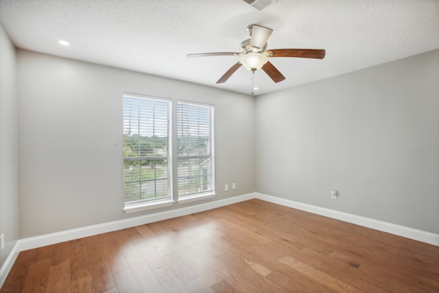 unfurnished room featuring ceiling fan, a textured ceiling, and light wood-type flooring