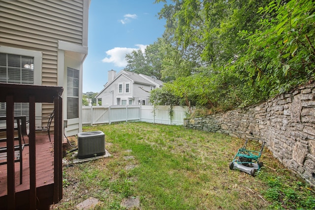 view of yard with central air condition unit and a deck