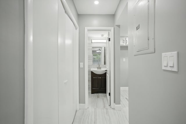 corridor featuring electric panel and sink