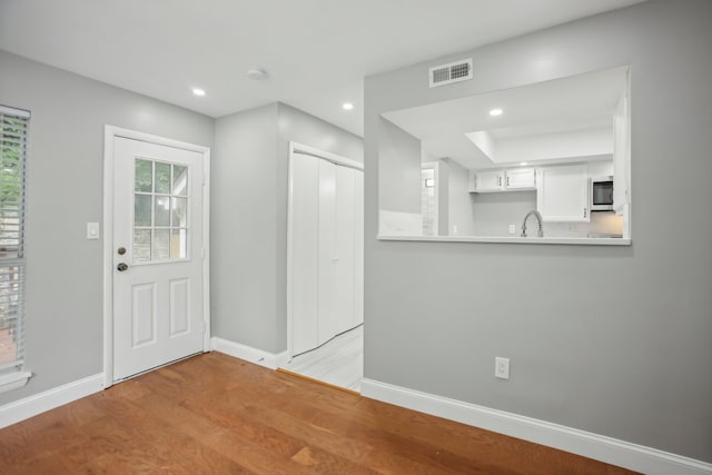 foyer entrance featuring sink and light hardwood / wood-style flooring