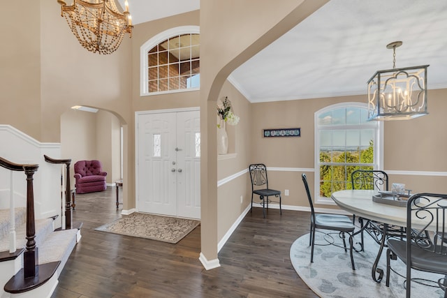 entrance foyer with ornamental molding and dark hardwood / wood-style floors