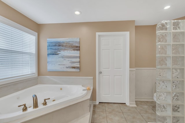 bathroom with a tub to relax in and tile patterned floors