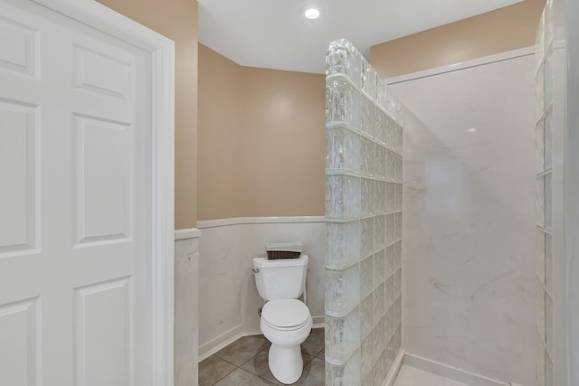 bathroom with tile patterned flooring, toilet, and walk in shower