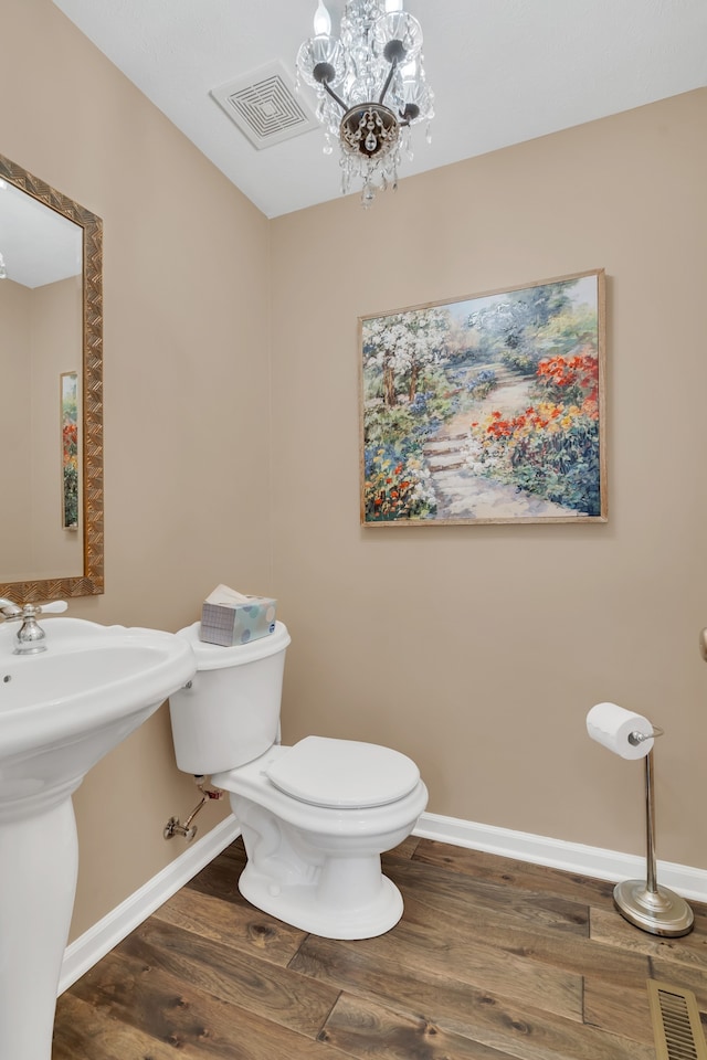 bathroom featuring sink, a chandelier, wood-type flooring, and toilet