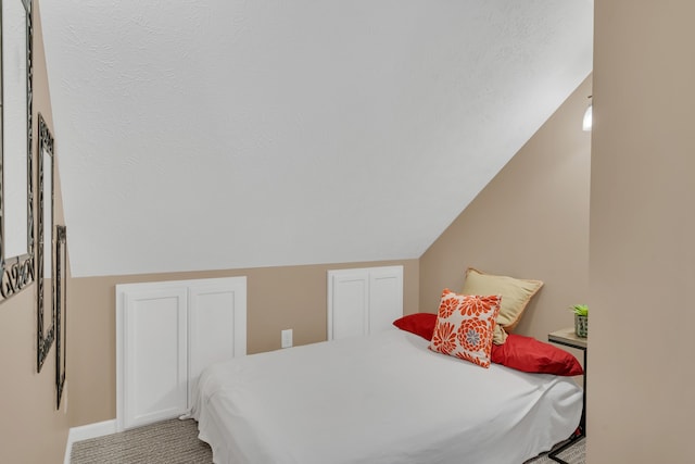 bedroom featuring vaulted ceiling and light colored carpet