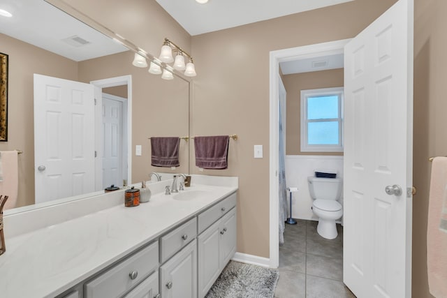 bathroom with tile walls, vanity, toilet, and tile patterned floors