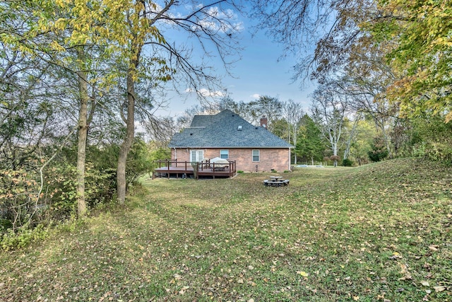 rear view of house featuring a yard and a wooden deck