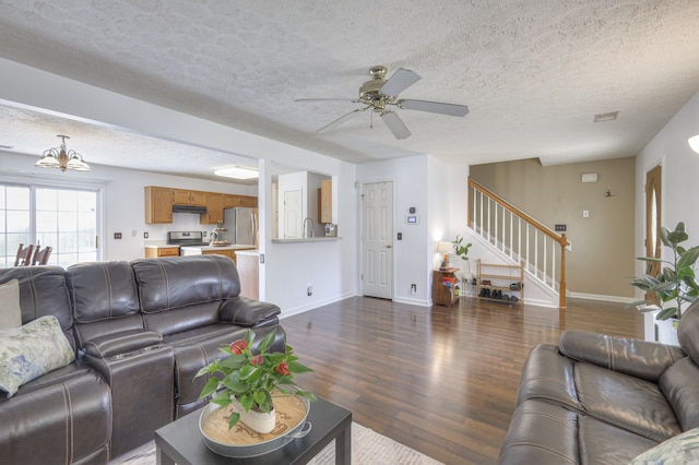 living room featuring ceiling fan with notable chandelier, a textured ceiling, dark hardwood / wood-style floors, and sink