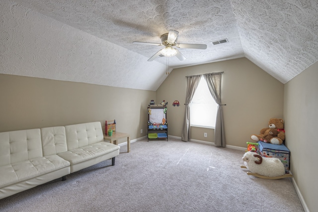 rec room featuring ceiling fan, carpet floors, a textured ceiling, and vaulted ceiling