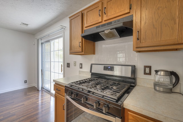 kitchen with a textured ceiling, gas stove, and dark hardwood / wood-style floors