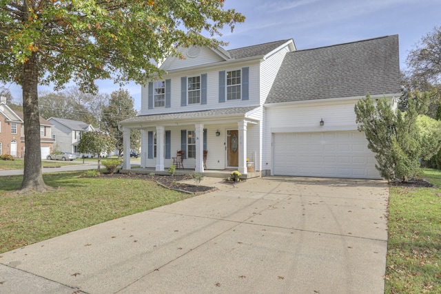 view of front of property with covered porch, a garage, and a front lawn