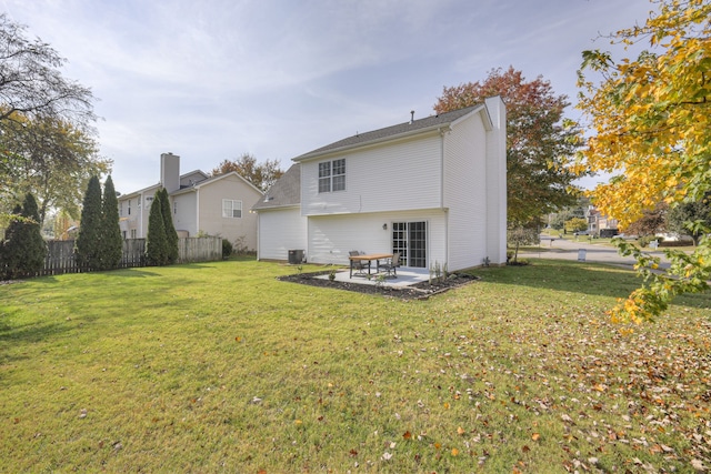 rear view of house featuring a lawn, cooling unit, and a patio