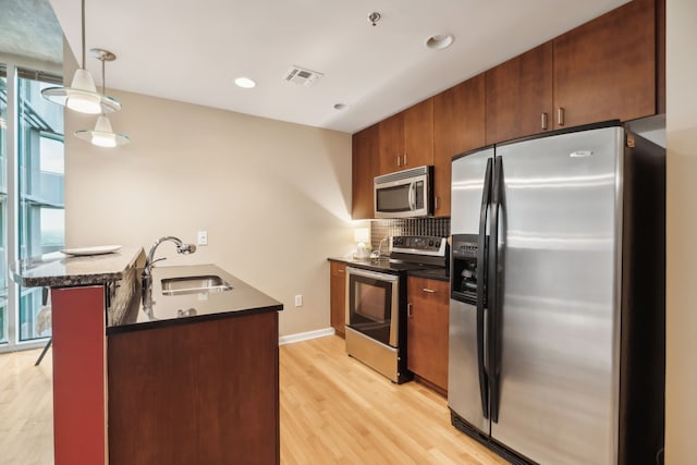 kitchen with a wealth of natural light, sink, appliances with stainless steel finishes, and kitchen peninsula