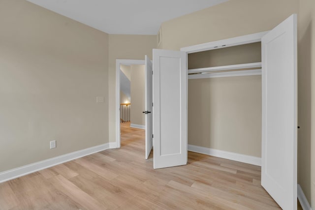 unfurnished bedroom featuring light wood-type flooring and a closet