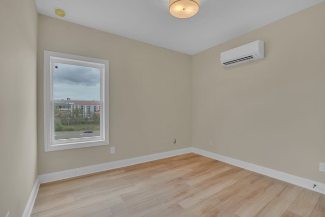 spare room featuring light hardwood / wood-style floors and a wall mounted air conditioner