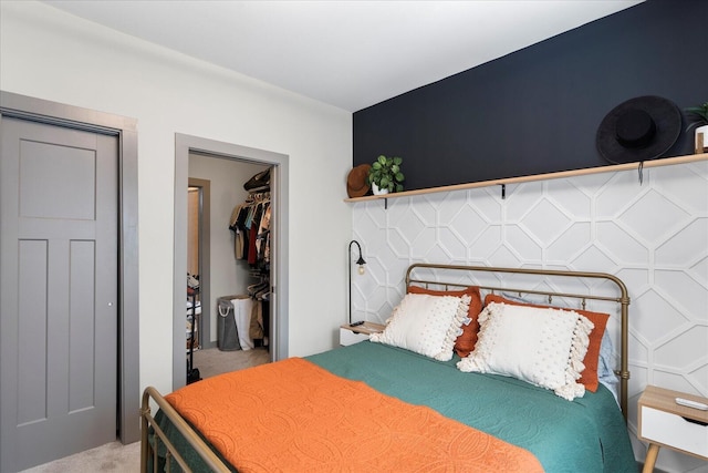 bedroom with a spacious closet, light carpet, and a closet