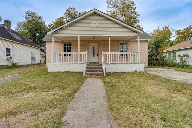 bungalow with a front yard, cooling unit, and a porch