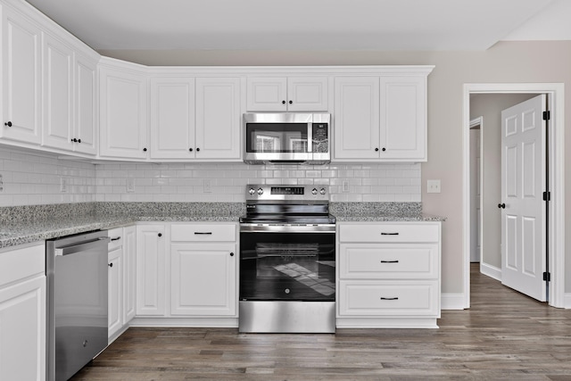 kitchen with appliances with stainless steel finishes, dark hardwood / wood-style floors, and white cabinets