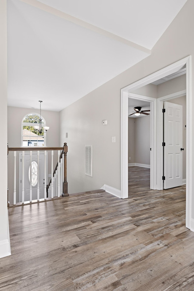 interior space featuring lofted ceiling, hardwood / wood-style floors, and a chandelier